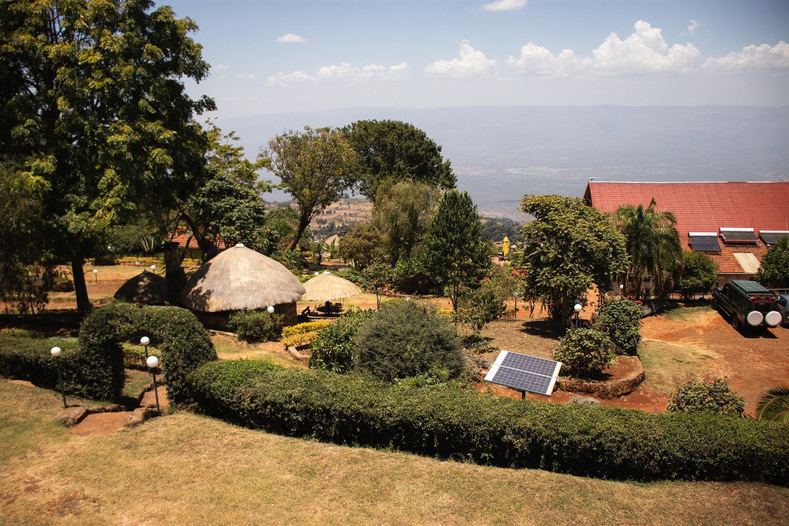 The Kerio View grounds seen from above, thatched bandas and clipped hedges with the Rift Valley beyond