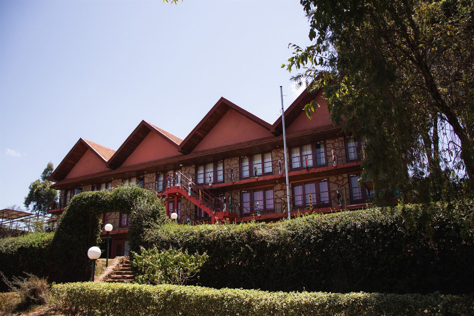 The main lodge building at Kerio View, red roof above a clipped hedge