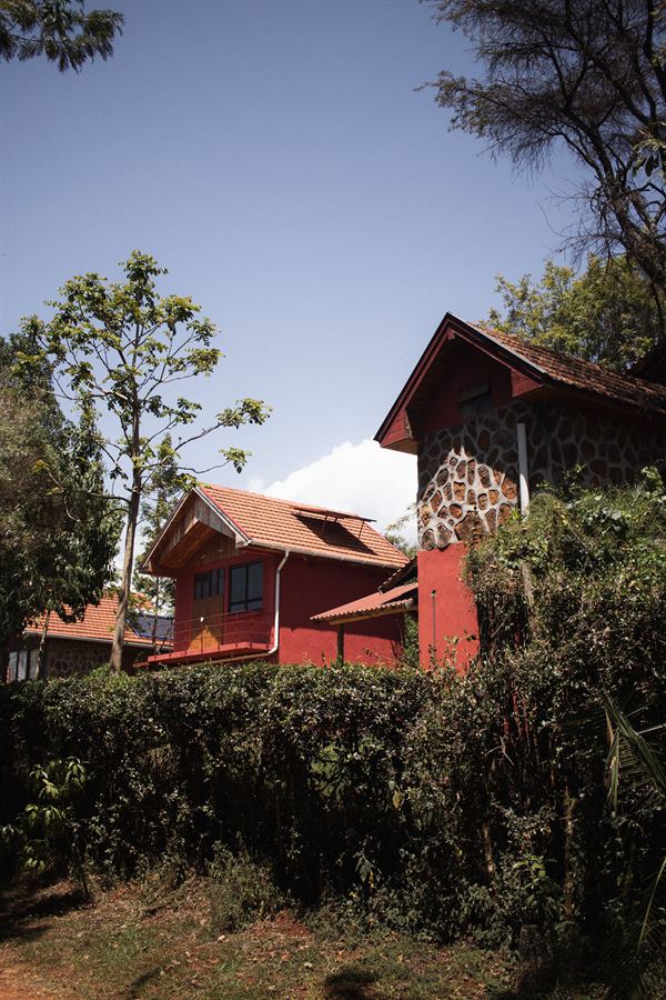 The red-walled cottages at Kerio View Lodge under a clear sky